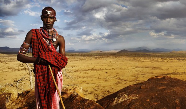 Maasai young man stands in a field