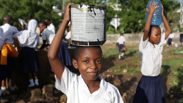 Eva collects water at Mbuyuni school garden in Dar es Salaam, Tanzania.